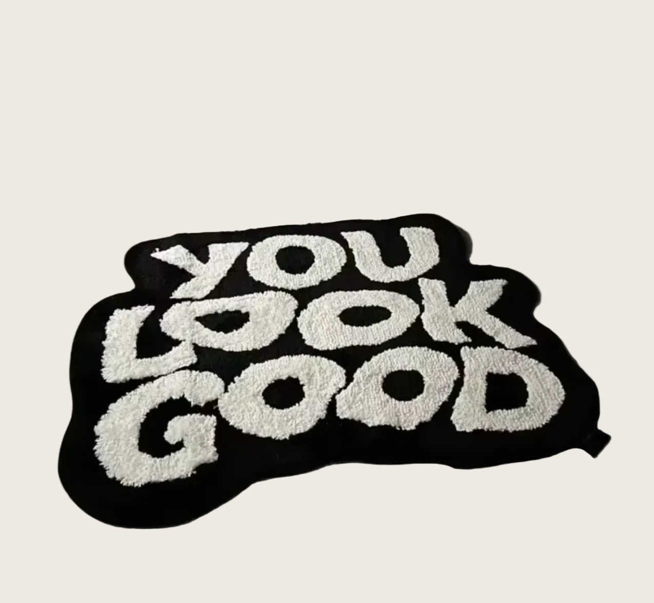 Black rug with 'YOU LOOK GOOD' text on a wooden floor